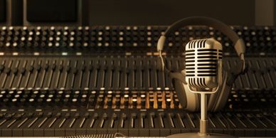 Retro microphone with headphones in front of a sound mixer.