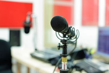 Close-up of a microphone in a studio setting.