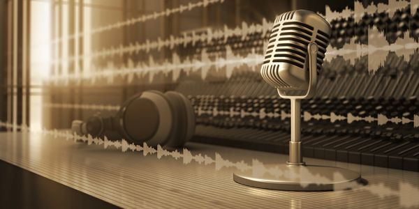Vintage microphone and headphones on a piano with sound waves overlay.