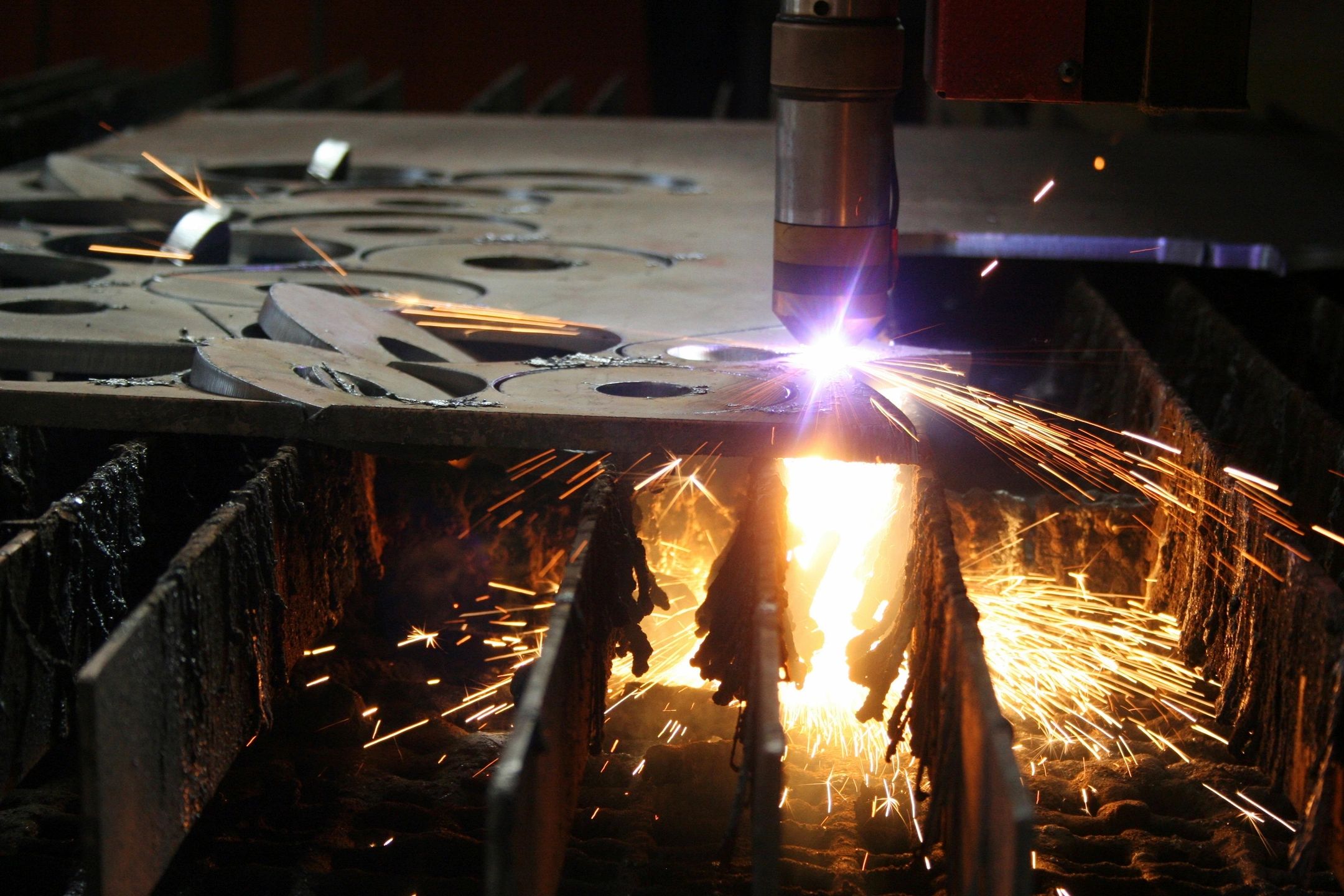 Industrial metal cutting with sparks flying.