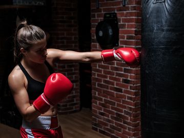Woman boxing with a punching bag.