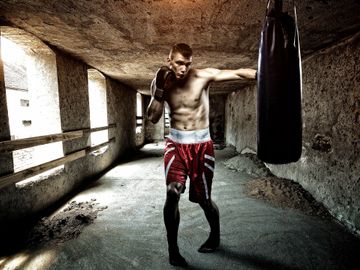 A make boxer punches the boxing bag