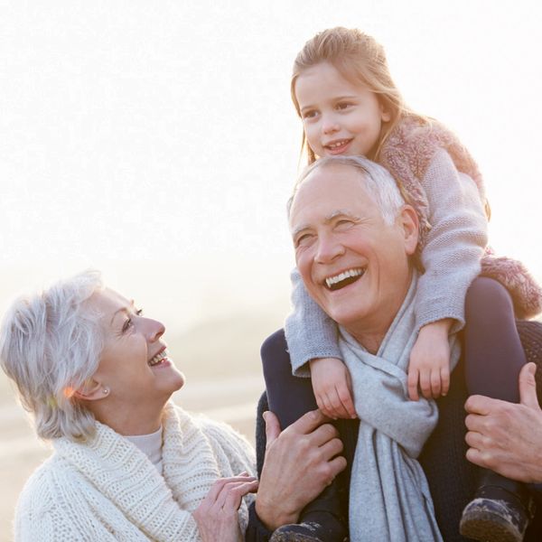 Grandparents joyfully spending time with their granddaughter outdoors.