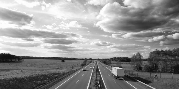 Highway stretching through open countryside under a cloudy sky.