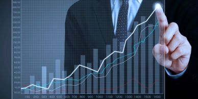 Businessman pointing at rising financial graph showing growth.