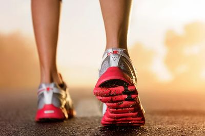 Close-up of a runner's shoes on a road.