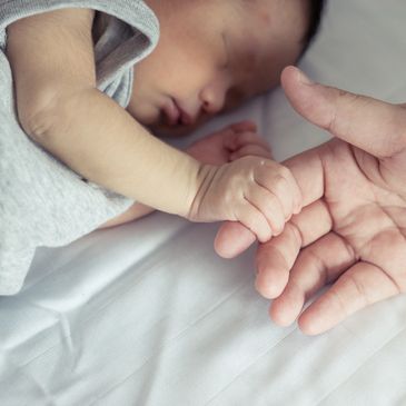 infant holding finger