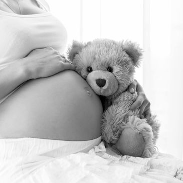 pregnant woman with sleeping stuff animal bear