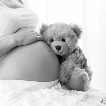 pregnant woman with sleeping stuff animal bear