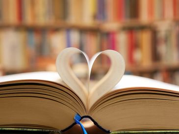 Open book with paper folded into a heart-shape