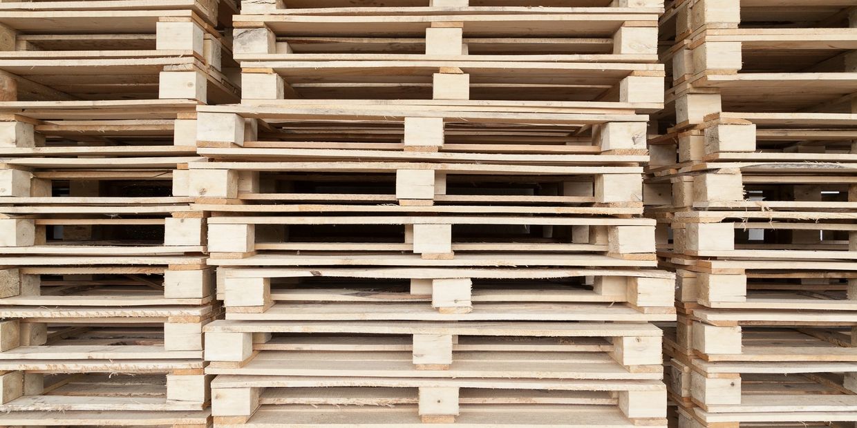 Stacks of wooden pallets neatly arranged in rows.
