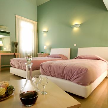 Cozy twin bedroom with green walls and pink bedding.