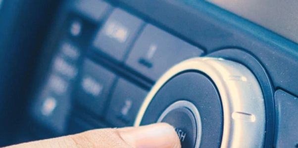 Finger pressing a car audio control knob labeled 'Push'.