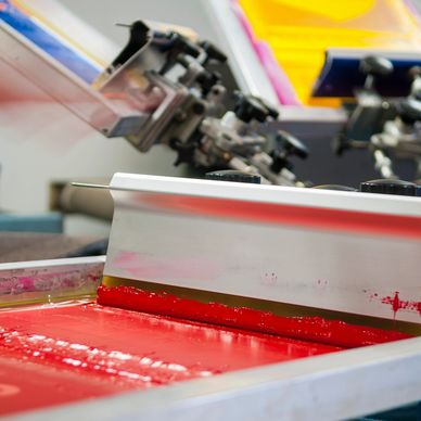 Red ink squeegee used for hand printed shirts on the manual Screen Printing press