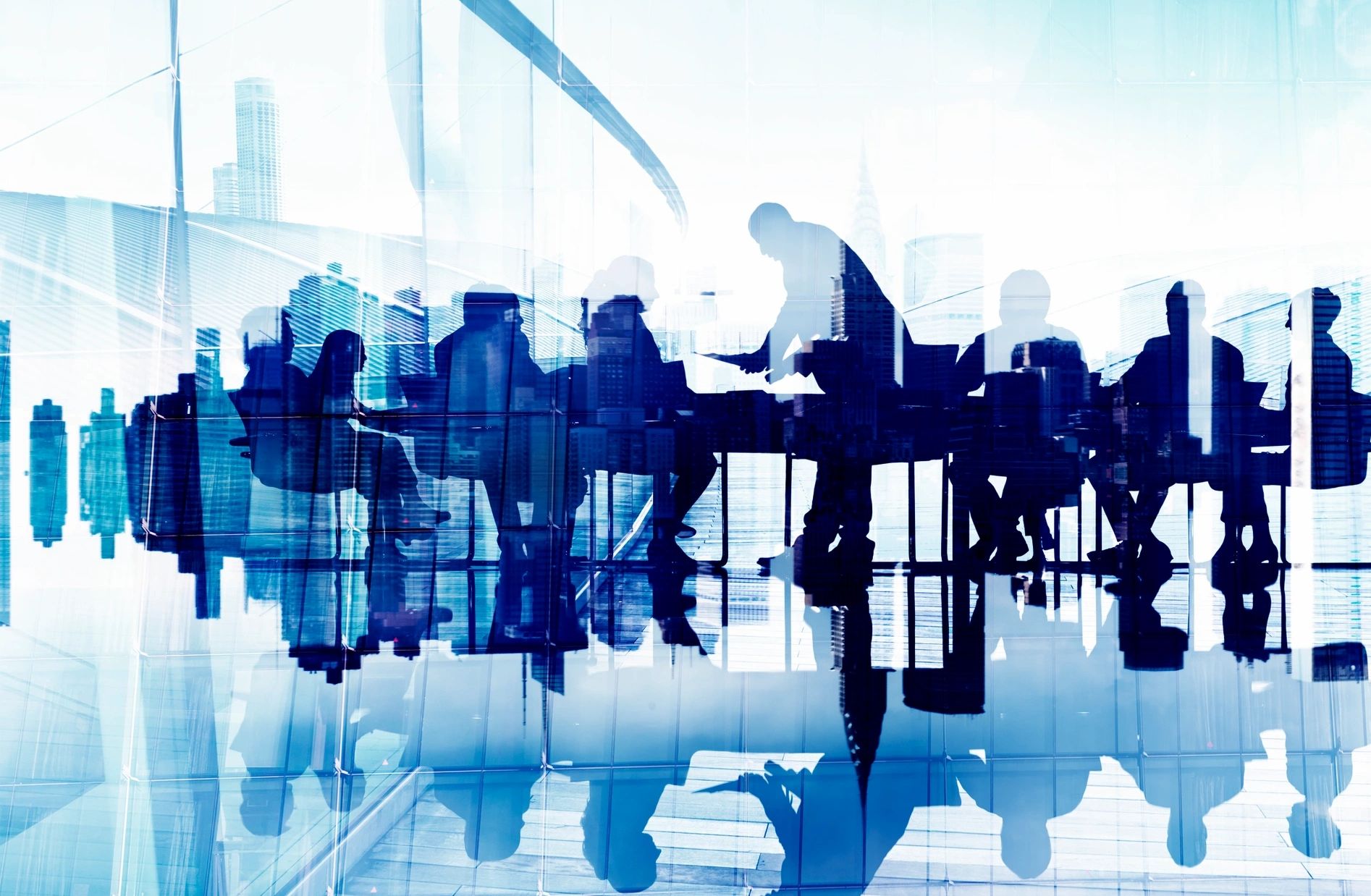 an image showing workplace with employees sitting across table. 