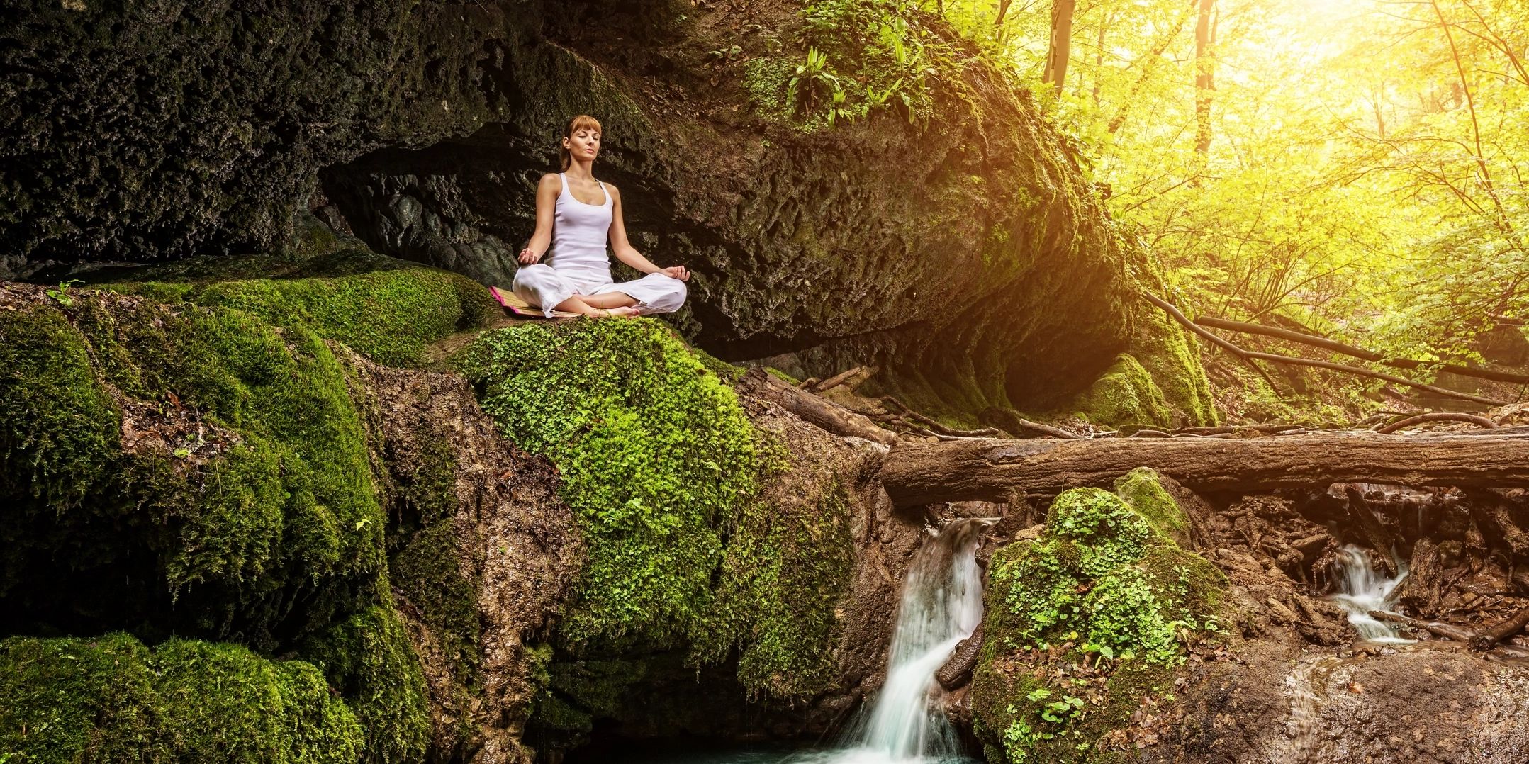 Person meditating by waterfall