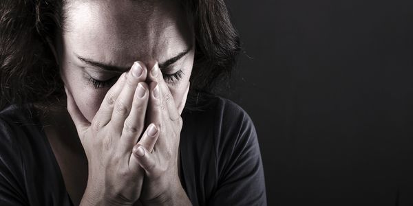 woman crying into her hands