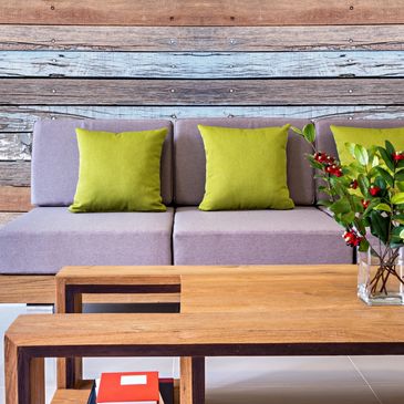 Modern living room with purple sofa, green cushions, and wooden coffee tables.