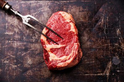 A FOrk Poking the Meat Side of a Beef Slice