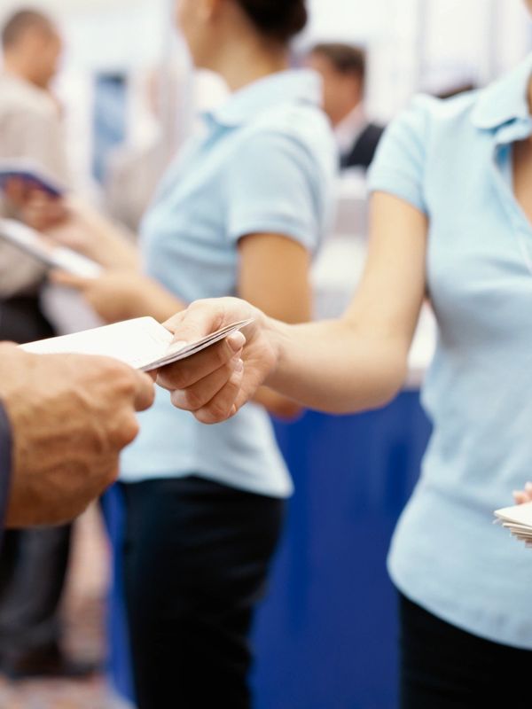 A woman handing a man an envelope for Corbett Bookkeeping.