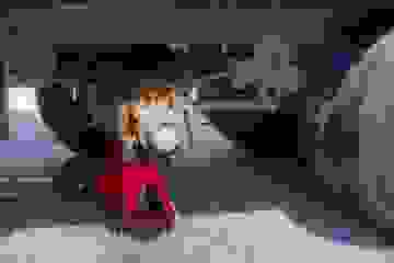 A trolley jack and axle stand underneath a truck with one of its wheels off.