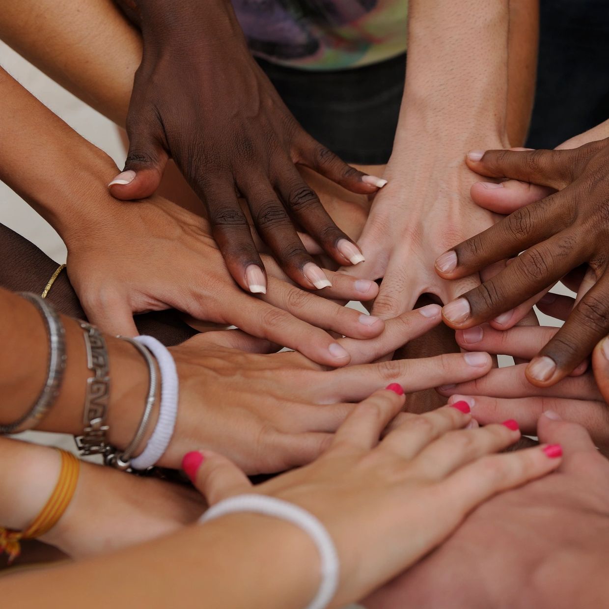 Diverse hands stacked together in unity.