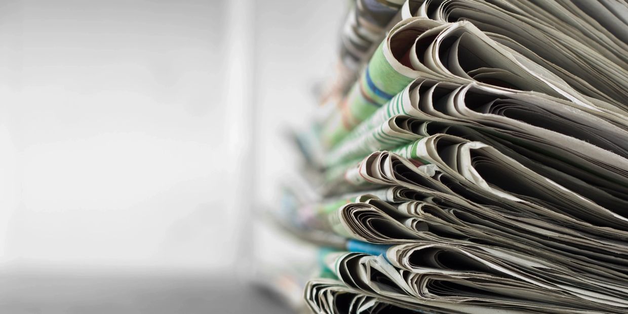 Close-up of a stack of folded newspapers.