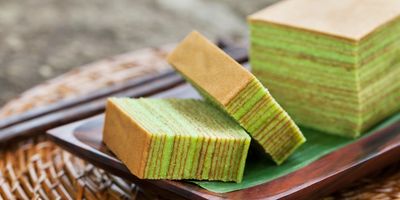 A rectangle lime and lemon colored cake with two pieces cut off