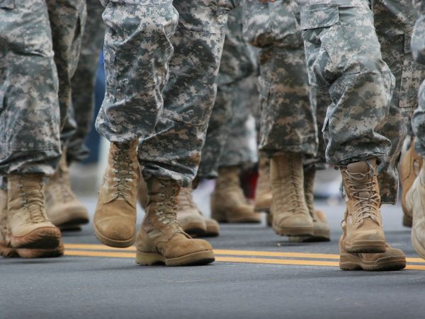Close-up of soldiers marching in military boots and camouflage pants.