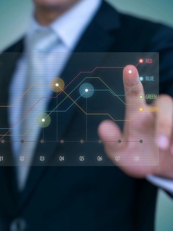 Businessman interacts with a futuristic digital line graph showing quarterly data trends.