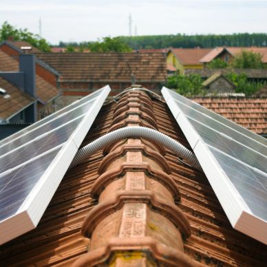 Solar panels installed on a tiled rooftop with a cable connecting them.