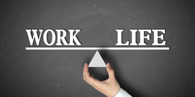 A hand holding a triangle with the words "Work" and "Life" to show that they are balanced.