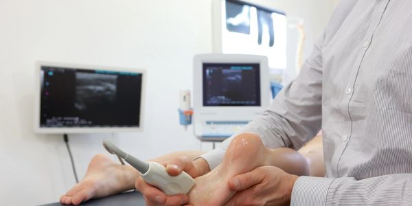 Medical professional performing ultrasound on a patient's foot.
