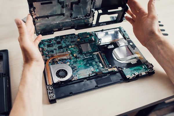 Laptop on desk opened to expose motherboard
