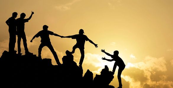 夕阳下，几人相互扶持攀登山峰。