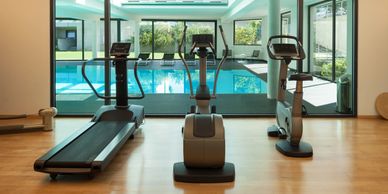 Exercise machines and a swimming pool in a leisure centre. Click to view the leisure centres lists
