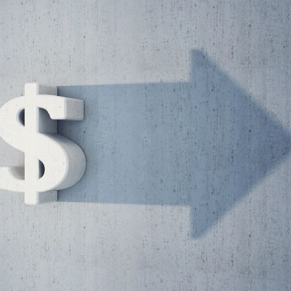 A dollar sign casting a shadow shaped like an arrow pointing right.