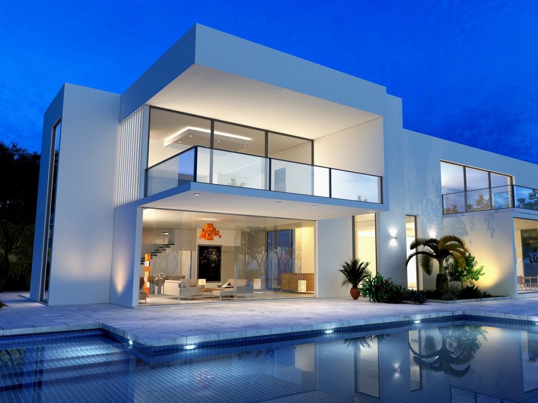 Modern white house with glass balcony and pool at dusk.