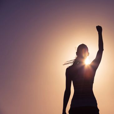 Woman with fist in the air cloud backdrop