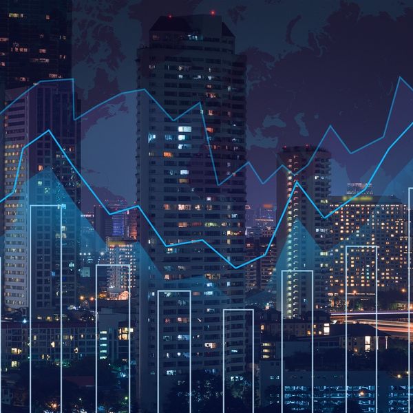 Night city skyline with financial graphs overlaying buildings.
