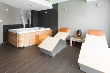Zona de relax con jacuzzi y tumbonas modernas.