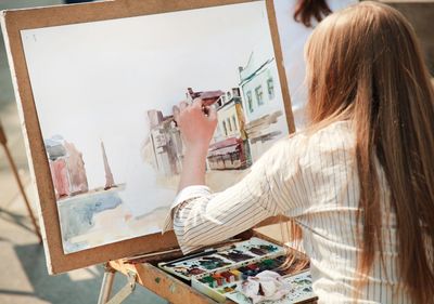 backside of a woman making a painting 