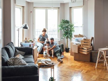 A family enjoys time together in their new home surrounded by moving boxes.
