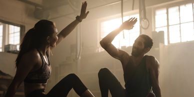 Two people giving a high-five during a workout.