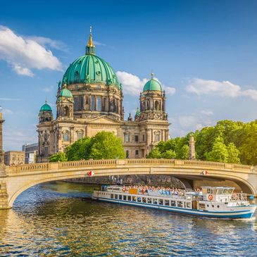 European river cruise boat passing under bridge in Prague in front of cathedral