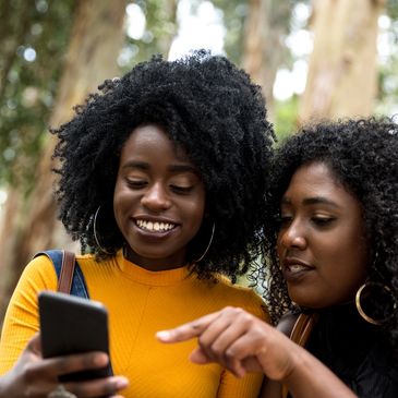 Two attractive women of color viewing content on a mobile device