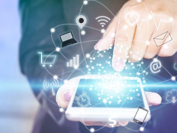 Hand interacting with smartphone displaying digital icons.