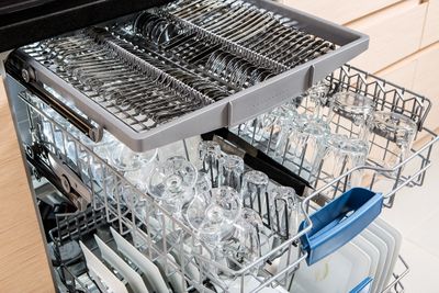 An open dishwasher with clean dishes on the rack.