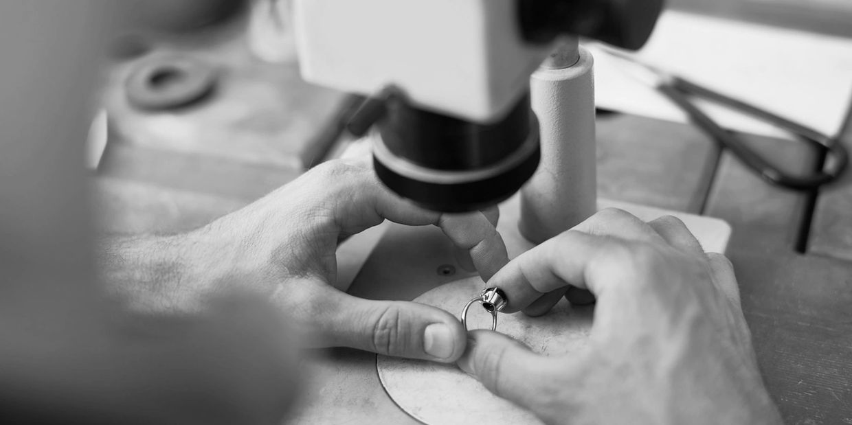 Person using microscope to evaluate jewelry
