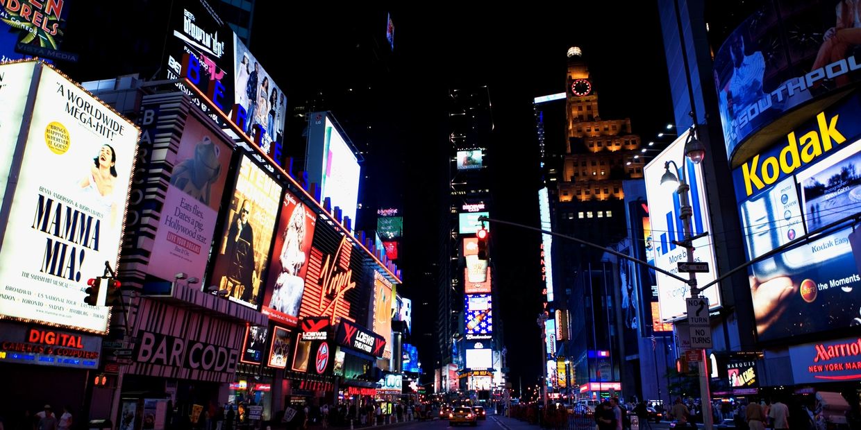 Times Square at night with bright billboards and bustling streets.